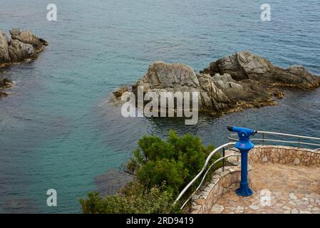 Rochers avec vue sur la mer et télescope touristique. Observation du télescope Sea Rocks. Jumelles fixes, télescope, tour de visualisation ou lunette, vagues océaniques sur rocheux Banque D'Images