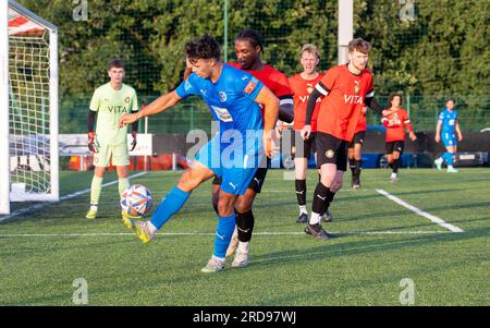 Warrington Rylands Scott Bakkor contrôle le ballon devant un défenseur de Stockport Town au Stockport Sports Village sur un terrain 3G. Banque D'Images