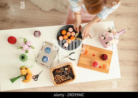 Des filles dans la cuisine fabriquent des fleurs à partir de savon. Hobby, processus créatif. Cadeaux DIY. Les mains et les fleurs des femmes. Savon fait main. Fête des mères, Fête des femmes Banque D'Images