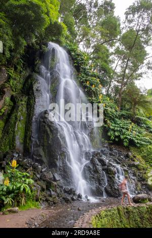 Cascade dans le jardin botanique de Ribeira do Guilherme dans le Nordeste avec des touristes, île Sao Miguel aux Açores. Banque D'Images