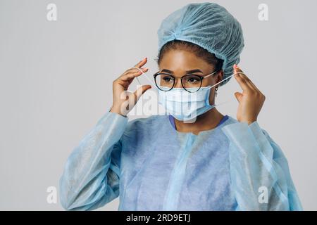 Portrait d'une jeune femme afro-américaine médecin ou infirmière sur un vêtement de protection médical avec masque Banque D'Images