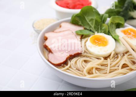 Délicieux ramen avec de la viande sur la table blanche, gros plan avec espace pour le texte. Soupe de nouilles Banque D'Images