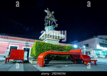 Tegucigalpa, Francisco Morazan, Honduras - 11 décembre 2022 : statue de l'Archange Saint Michel la nuit sur la place 'Los Dolores' sur un piédestal avec Re Banque D'Images