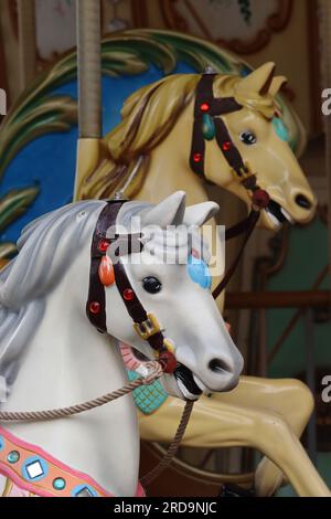 Gros plan sur les chevaux traditionnels colorés du carrousel de galoper du parc des expositions, montés sur un carrousel espagnol du parc des expositions sur le front de mer à la Coruna. Banque D'Images