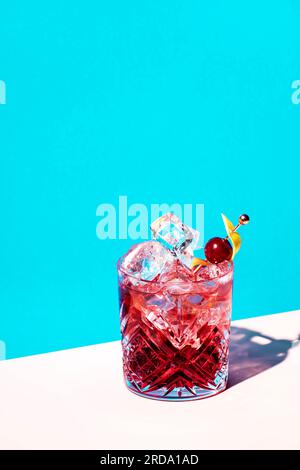 Cocktail alcoolisé Sbagliato Rosa avec liqueur rouge italienne et apéritif, rose champagne ou vin mousseux, décoré de zeste, brick bleu été Banque D'Images