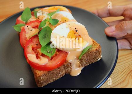 Gros plan de délicieux œufs durs avec sandwichs ouverts à la tomate et basilic Banque D'Images