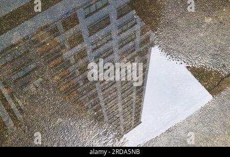 Gros plan des hauts bâtiments qui se reflètent sur la flaque d'eau Banque D'Images