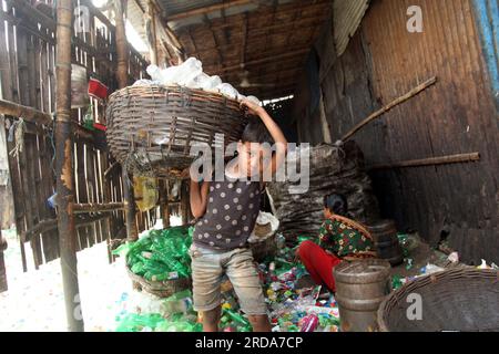 Dhaka, Dhaka, Bangladesh. 18 mars 2023. travailleur mineur ou le travail des enfants travaillent encore dans de nombreuses bouteilles en plastique recyclage factorie.photo a été prise kmar Banque D'Images