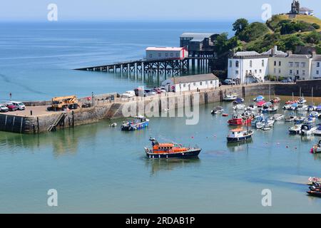 Une vue du port de Tenby avec la marée entrant, les stations de bateau de sauvetage anciennes et nouvelles sont visibles à gauche de la colline du château. Banque D'Images