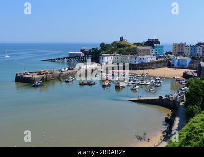 Une vue du port de Tenby avec la marée entrant, les stations de bateau de sauvetage anciennes et nouvelles sont visibles à gauche de la colline du château. Banque D'Images