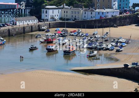 Une vue du port de Tenby avec la marée entrant, les stations de bateau de sauvetage anciennes et nouvelles sont visibles à gauche de la colline du château. Banque D'Images