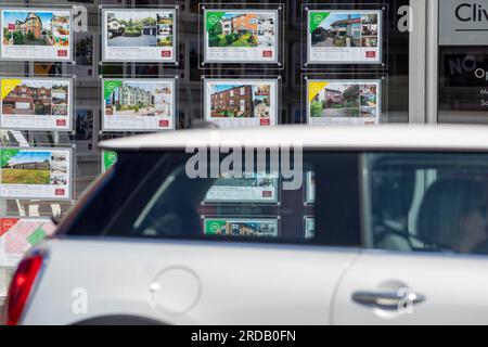 Agences immobilières fenêtres et panneaux de vente à West Kirby, Wirral, Merseyside, Royaume-Uni. Selon les analystes, le marché immobilier britannique devrait éviter un effondrement provoqué par la hausse des taux d’intérêt, malgré une baisse de l’inflation des prix de l’immobilier à zéro en mai. L'Office for National Statistics a déclaré qu'une baisse de la croissance mensuelle de 0,5% en avril à 0% en mai signifiait que le taux annuel d'inflation des prix de l'immobilier a chuté à 1,9%. Banque D'Images