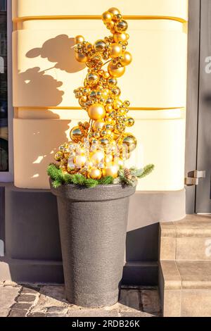 Arbre de Noël artificiel entièrement fait de boules dorées dans le pot. Noël drôles de boules d'or brillantes dans le pot de fleurs. Ornement recouvert d'un cache en pot alternatif Banque D'Images