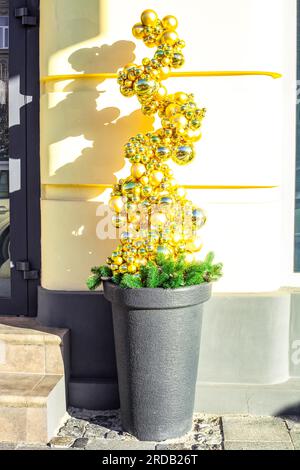 Arbre de Noël artificiel entièrement fait de boules dorées dans le pot. Noël drôles de boules d'or brillantes dans le pot de fleurs. Ornement recouvert d'un cache en pot alternatif Banque D'Images