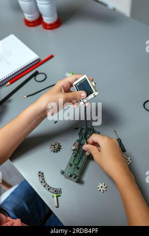 Étudiante connectant un panneau solaire à un circuit électrique dans un cours de robotique Banque D'Images