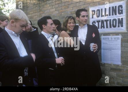 Les étudiants votent dans une élection générale 1990s. Les étudiants de l'Université d'Oxford se rendent au bureau de vote de la circonscription d'Oxford West et Abingdon et votent lors d'une élection générale parlementaire gouvernementale. Les étudiants de Black Tie ont été debout toute la nuit à un bal de mai. Oxford, Oxfordshire, Angleterre 1 mai 1997. ANNÉES 90 ROYAUME-UNI HOMER SYKES Banque D'Images