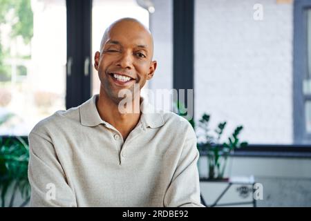 clichés de tête professionnels, homme gai à la peau foncée avec la maladie de myasthénie grave regardant la caméra, travailleur de bureau heureux avec le syndrome des yeux, inclusion a Banque D'Images