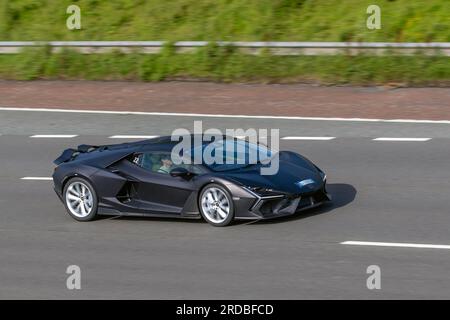 Lamborghini Revuelto, des proportions Lamborghini classiques aux lignes fortes et sculptées. Le tout premier hybride gaz-électrique rechargeable V12 de Lamborghini ; voyageant à grande vitesse sur l'autoroute M6 dans le Grand Manchester, au Royaume-Uni Banque D'Images