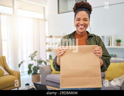 Restauration rapide, livraison et portrait de femme noire heureuse avec commande de colis dans sa maison, sourire, visage et client dame africaine avec sac de livraison de Banque D'Images