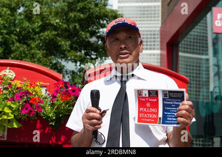 Uxbridge, Royaume-Uni. 20 juillet 2023. Candidat indépendant Joseph espérant chanter son chemin dans les pensées des électeurs. C'était une journée bien remplie dans le centre-ville d'Uxbridge, car les acheteurs étaient en déplacement et en route pour voter aux élections locales. L'ancien Premier ministre Boris Johnson a occupé le siège pour le Parti conservateur. Les travaillistes devraient gagner les urnes aujourd’hui, cependant, de nombreux électeurs sont furieux qu’Uxbridge fasse partie de la zone à ultra-faible émission proposée par le maire travailliste de Londres Sadiq Khan. Cela peut signifier que les électeurs votent pour des partis alternatifs tels que les libéraux démocrates ou les Verts. Crédit : MAU Banque D'Images