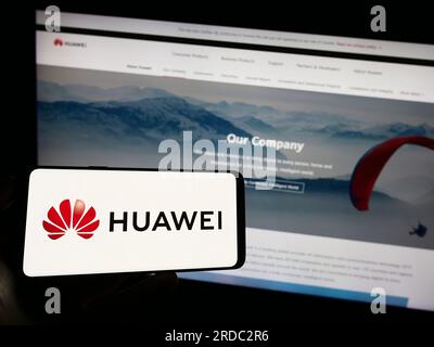 Personne tenant un téléphone mobile avec le logo de la société chinoise Huawei technologies Co. Ltd. Sur l'écran devant la page Web. Concentrez-vous sur l'affichage du téléphone. Banque D'Images