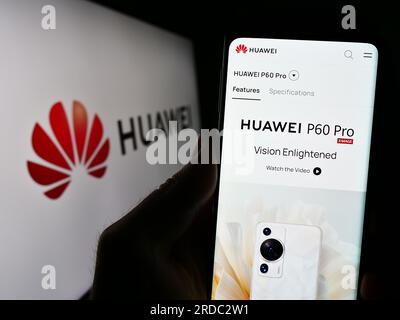 Personne tenant le téléphone portable avec le site Web de la société chinoise Huawei technologies Co. Ltd. Sur l'écran avec logo. Concentrez-vous sur le centre de l'écran du téléphone. Banque D'Images