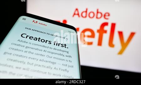 Téléphone mobile avec site Web du produit d'IA générative Adobe Firefly sur l'écran devant le logo de l'entreprise. Effectuez le focus sur le coin supérieur gauche de l'écran du téléphone. Banque D'Images