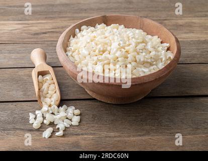 Canjica séché, maïs hominy ou blanc sur un bol sur une table en bois. Banque D'Images