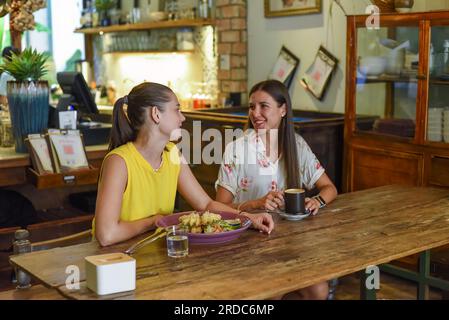 Deux meilleurs amis qui parlent et mangent dans un café Banque D'Images