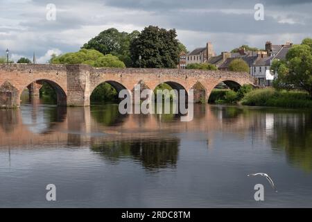 Une vue sur le pont Devorgilla et la rivière Nith dans le centre de Dumfries, en Écosse, par une journée nuageuse en été. Banque D'Images