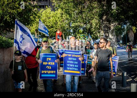 Les réservistes israéliens tiennent des pancartes qui indiquent en hébreu "il y a maintenant une armée populaire sans démocratie (L) et "le gouvernement d'Israël vous avez rompu le contrat avec les soldats de réserve" lors d'une manifestation à tel Aviv. Un plan controversé du gouvernement visant à réformer le système judiciaire du pays a brisé de profondes divisions au sein de la société israélienne. Ces divisions ont infiltré les forces armées, où les réservistes des unités stratégiques clés se sont engagés à ne pas se présenter à la réserve si les changements législatifs sont poussés à adopter. (Photo Eyal Warshavsky / SOPA Images/Sipa USA) Banque D'Images