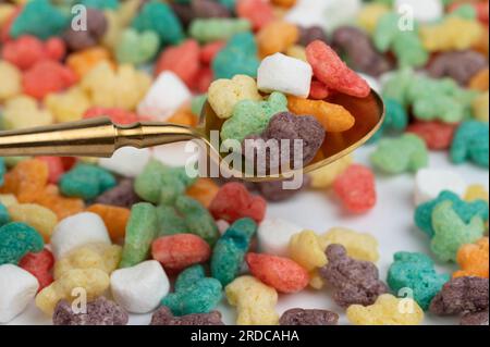 Cornflakes colorés dans la cuillère d'or macro vue de gros plan Banque D'Images