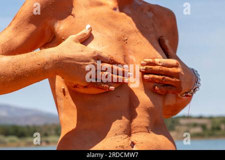 Réhabiliter, exfolier et guérir bain de boue sur la peau d'une femme, dans un lac en Castilla y León en Espagne. d'argile Banque D'Images