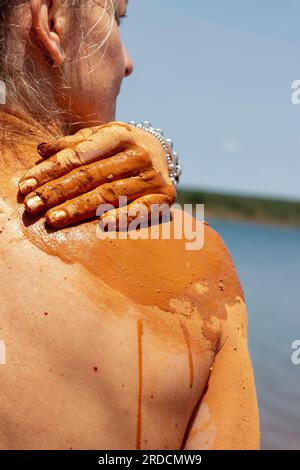 Réhabiliter, exfolier et guérir bain de boue sur la peau d'une femme, dans un lac en Castilla y León en Espagne. d'argile Banque D'Images