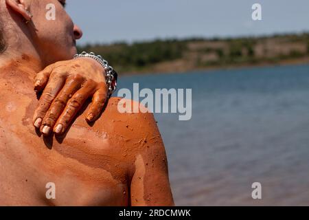 Réhabiliter, exfolier et guérir bain de boue sur la peau d'une femme, dans un lac en Castilla y León en Espagne. d'argile Banque D'Images