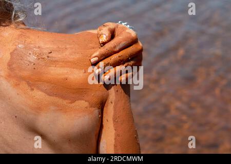 Réhabiliter, exfolier et guérir bain de boue sur la peau d'une femme, dans un lac en Castilla y León en Espagne. d'argile Banque D'Images