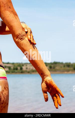 Réhabiliter, exfolier et guérir bain de boue sur la peau d'une femme, dans un lac en Castilla y León en Espagne. d'argile Banque D'Images