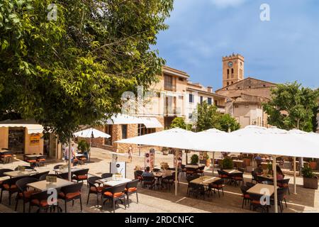 Petite place confortable avec petits commerces et terrasses dans le charmant village montagneux au nord de l'île méditerranéenne de Majorque en Espagne. Banque D'Images