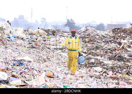 Nairobi, Kenya. 14 juillet 2023. Un homme vu marchant à travers les ordures à la décharge de Dandora. Le gouvernement du comté de Nairobi prévoit de mettre en place une usine de recyclage qui transformera en énergie les déchets déposés sur la décharge de Dandora. Le vaste site de décharge reçoit environ 2 000 tonnes de déchets par jour, ce qui en fait le site de travail le plus fréquenté pour les récupérateurs de déchets à trouver du plastique et d'autres matières recyclables. (Photo Allan Muturi/SOPA Images/Sipa USA) crédit : SIPA USA/Alamy Live News Banque D'Images