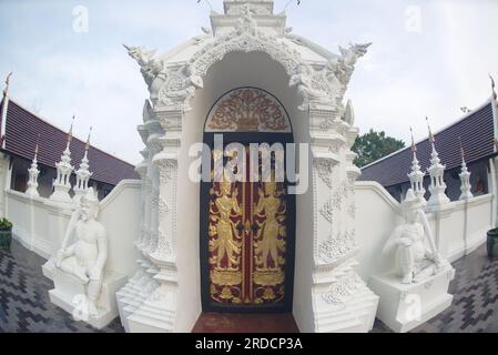 La porte d'entrée de Phra Chedi Chai Mongkhon si Dvaravati avec de belles sculptures en stuc et en bois à Wat Pa Pathomchai. Banque D'Images