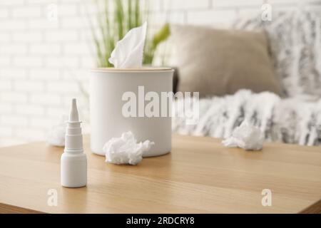 Gouttes nasales avec boîte de mouchoirs sur la table dans la salle de séjour, gros plan. Concept d'allergie Banque D'Images