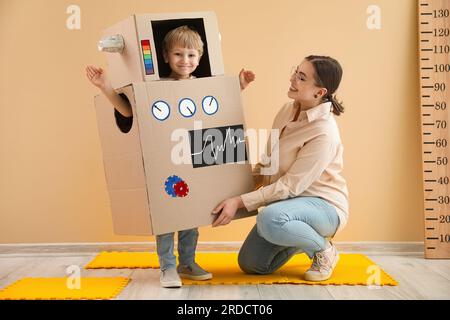 Petit garçon en costume robot en carton avec nounou à la maison Banque D'Images