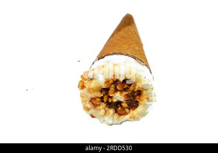 Cône de vanille de crème glacée avec garniture de morceaux de pépites de chocolat, noix et caramel dans une galette croustillante cônes, foyer sélectif de la fonte de la crème glacée froide twi Banque D'Images