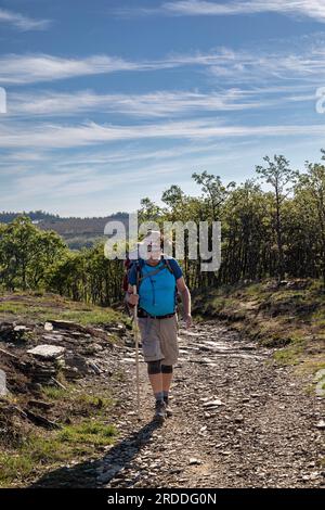 Un homme marchant à Foncebadon le long du Camino à Santiago de Compostelle, Espagne Banque D'Images