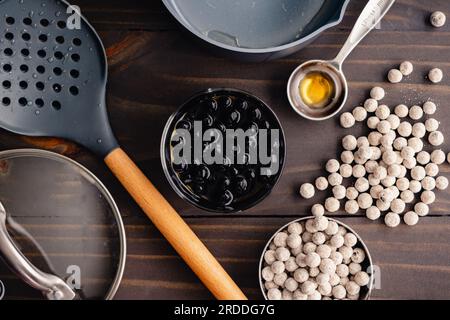 Cooked Boba in Syrup Surrounded by Utensils: Quick cook boba pearls with a small saucepan and other kitchen equipment Stock Photo