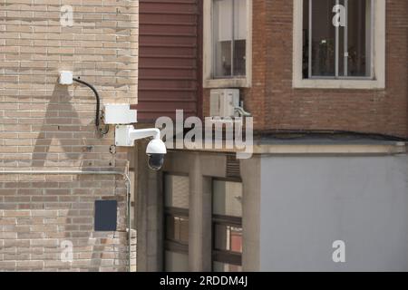 Coin de rue avec caméras de surveillance sur une façade d'un bâtiment en briques brun clair Banque D'Images