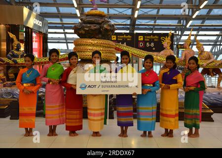 Un groupe de femmes portant des vêtements traditionnels thaïlandais, tenant un message de Airports of Thailand public Company Limited (AOT), accueillent les visiteurs au niveau des départs, juste après les contrôles d'immigration, aéroport international Suvarnabhumi, Bangkok, Thaïlande, Asie, 2014 Banque D'Images