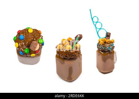 Milkshake au chocolat avec crème fouettée, biscuits, gaufres, servi dans un pot de maçon en verre. Un doux cocktail « fou ou fou ». Isolé. Espace pour le texte ou la conception. Banque D'Images