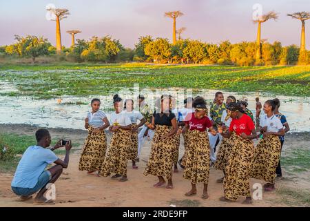 Morondava, Madagascar - 29 mai 2023 : un groupe de chanteuses au coucher du soleil à l'avenue Baobab Trees allee près de Morondava Banque D'Images