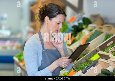 personnel de l'épicerie avec presse-papiers dans l'épicerie Banque D'Images